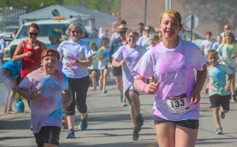 students and adults running in tshirts with color on them