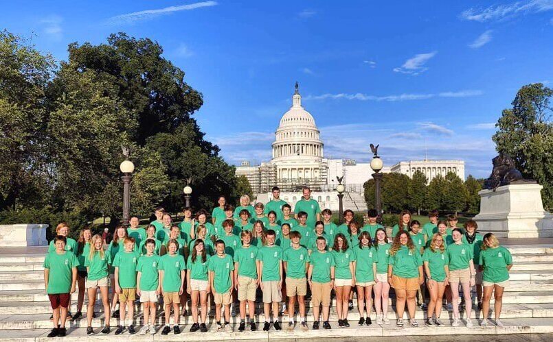 group of students in green shirts standing in front of US Capitol